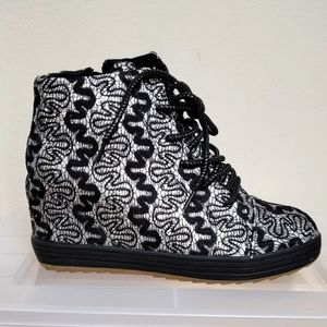 Black and pewter wedge sneakers with metallic stitching and glitter.